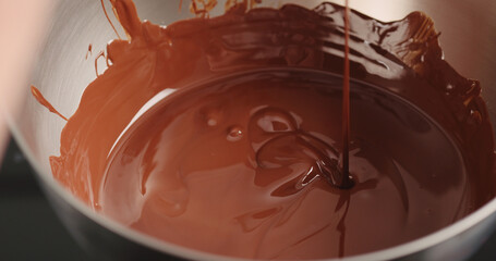 mixing dark melted chocolate with spoon closeup