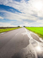 A road with a few puddles on it