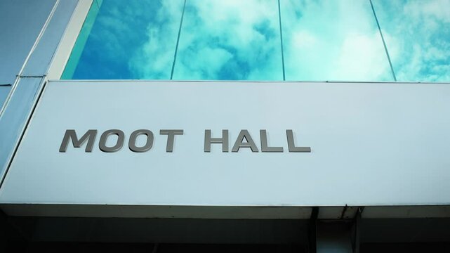 Moot Hall sign on a historic building with sky reflection in glass windows, symbolizing heritage, civic history, and architectural significance