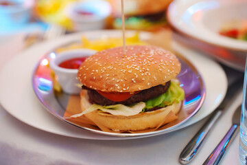 Metal plate with burger, french fries and tomato sauce. 