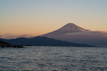 朝焼けの富士山を海岸から眺める