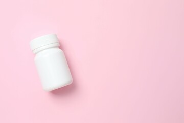 White bottle on pink background, top view