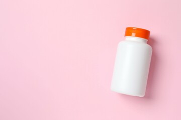White bottles on pink background, top view