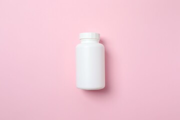 White bottle on pink background, top view