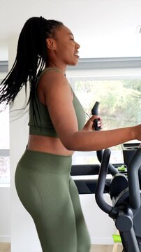 Businesswoman exercising on elliptical machine in hotel gym