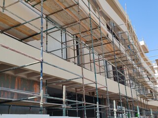 Scaffolding Erected Around Under Construction Building. 
Safety Scaffolding Protection Covered The Front Of Under Construction Skyline 
04 Floor Residential Under Construction Tower Structure. 