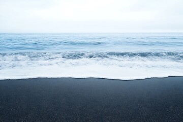 Obraz premium Black sand beach with ocean waves and cloudy sky perfect for coastal scenic travel