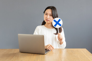 バツ印を出すPC前のアジア人女性01
