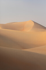 Sand dunes of Liwa desert in fog during sunrise hours.