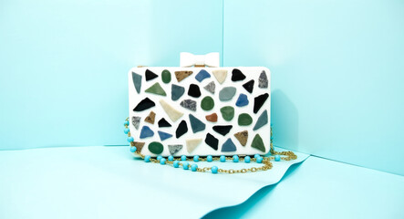 white mosaic clutch bag with turquoise beaded chain and bow