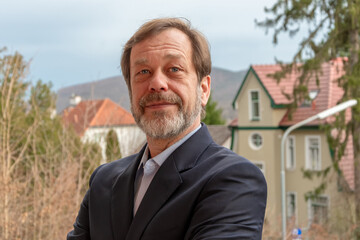 Business portrait of a successful man 50-55 years old outdoors with natural light.