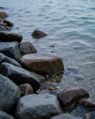 dark stones in shallow water at the lakeshore