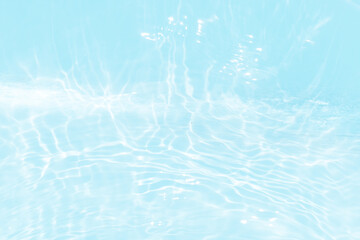 Blue water with ripples on the surface. Defocus blurred transparent blue colored clear calm water surface texture with splashes and bubbles. Water waves with shining pattern texture background.