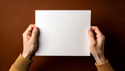 Obraz premium Generated image hands of man hold a white blank paper on brown background