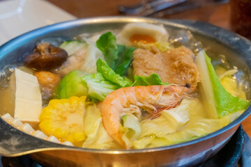 A steaming hot pot feast brings together fresh ingredients and rich flavors in a warm, communal dining experience. The bubbling broth, infused with aromatic spices, serves as the perfect base for cook