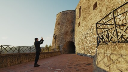 Elderly Man Tourist Observes a Historic Building Defensive Castle in Calabria