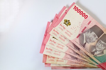 One Hundred Thousand Indonesian Rupiah Notes on a White Surface