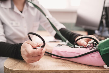close-up image of doctor using sphygmomanometer tonometer to measure patient's blood pressure....