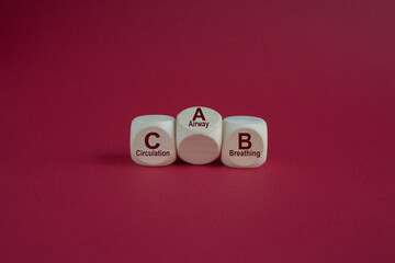 Dices form the acronym CAB (Circulation, Airway, Breathing). Beautiful red background. Symbol for basic life support.