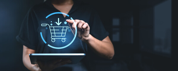 Woman using a tablet with a holographic shopping cart icon, representing online shopping and e-commerce technology. © ImageFlow