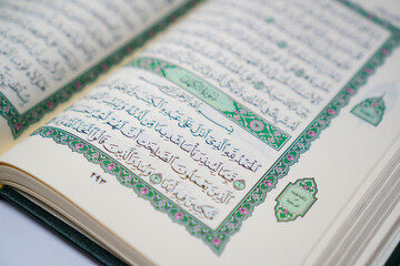 An open Quran displaying Surah Al-Kahf, a chapter of wisdom and guidance, often recited on Fridays...