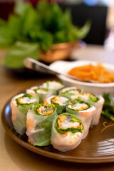 Vietnamese spring rolls with rice noodles, shrimp, lettuce, and fresh herbs are served with fish sauce and hoisin sauce mixtures.