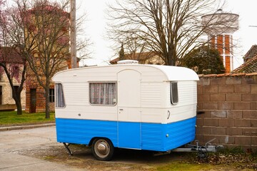 Un antiguo remolque caravana de color blanco y azul.