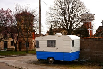 Un antiguo remolque caravana de color blanco y azul.