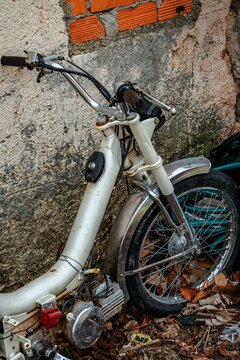 Antiguo ciclomotor abandonado de color blanco.
