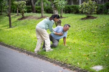 A daughter helping her father, old elderly sick senior Asian man got heart attack  at park. Health...