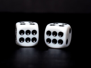 close up of a pair of white dice showing double six against a black background