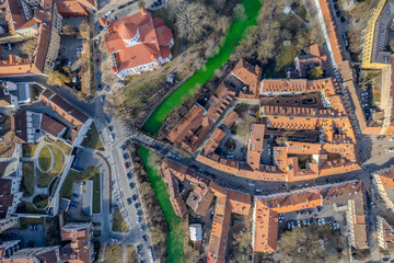 Fototapeta premium Aerial spring day view of emerald green Vilnelė river for irish St. Patrick's Day in Uzupis district, Vilnius, Lithuania