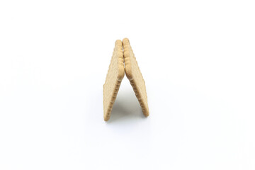 Two biscuits leaning on each other, on white background 
