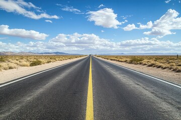 Naklejka premium Road through desert landscape vanishing towards horizon. Sunny blue sky
