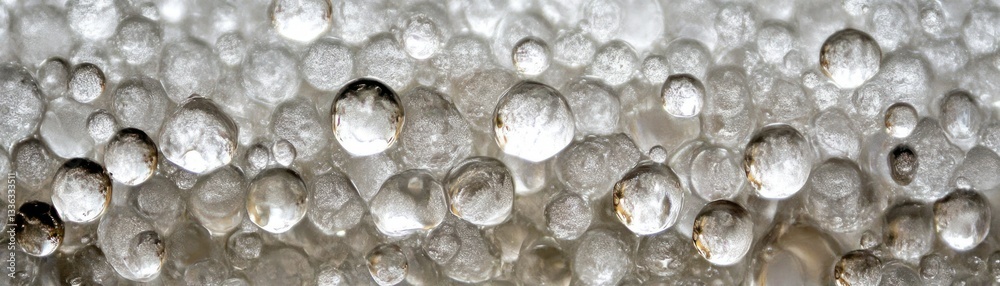 Poster a macro photograph showing numerous clear spheres and their reflections