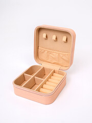Beige open empty box casket with small items and jewelry on white background