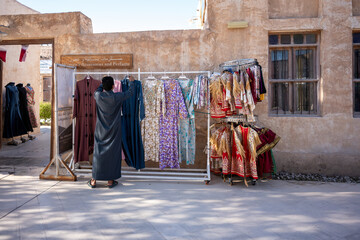 Fototapeta premium Arabic traditional kaftan dresses. Dresses on hangers in a clothing store in souq wakrah