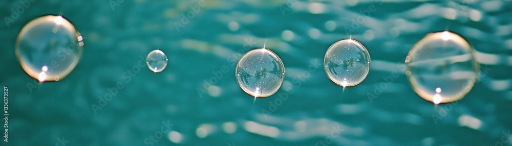Poster several translucent bubbles floating on top of teal colored water