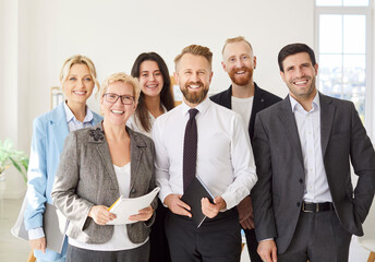 Corporate office team, smiling diverse employees group with confident executive standing in modern room, looking at camera, successful startup founder, staff and hr members posing at meeting, welcome