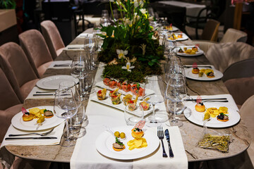 Elegant floral centerpiece with white tulips and lush greenery on a luxurious dining table