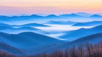 Obraz premium Serene landscape of blue mountain ranges under a colorful sunrise sky
