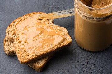Delicious and healthy peanut butter on black background