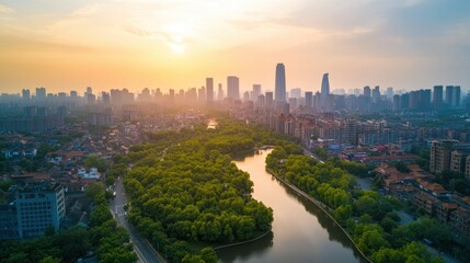 Obraz premium Aerial view of a cityscape with a river and trees at sunset