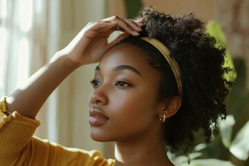 Haircare Treatment. Black woman applying serum or essential oil, caring for damaged dry hair, sitting in bathroom at home. Morning beauty routine