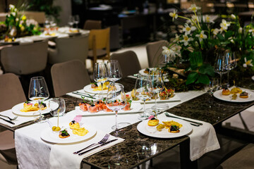 Luxurious dining table setup featuring gourmet appetizers, elegant glassware, floral centerpiece