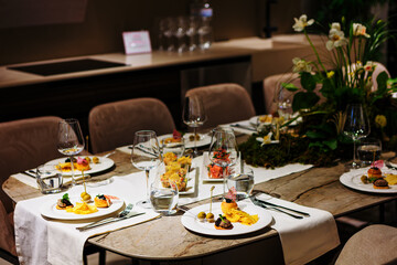 Luxurious dining table setup featuring gourmet appetizers, elegant glassware, floral centerpiece