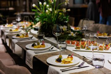 Luxurious dining table setup featuring gourmet appetizers, elegant glassware, floral centerpiece