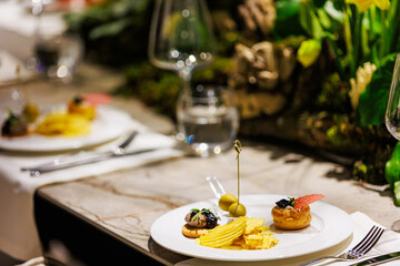 Elegant gourmet appetizers served on white porcelain.