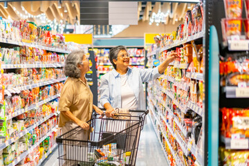 Happy Asian senior woman shopping at supermarket. Healthy elderly women friends enjoy urban...