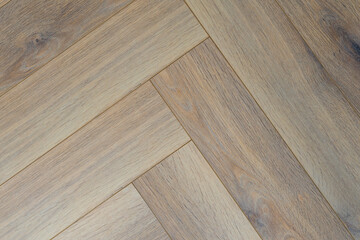 Naklejka premium Exquisite herringbone parquet texture in warm gray tones, creating coziness and elegance in the interior.